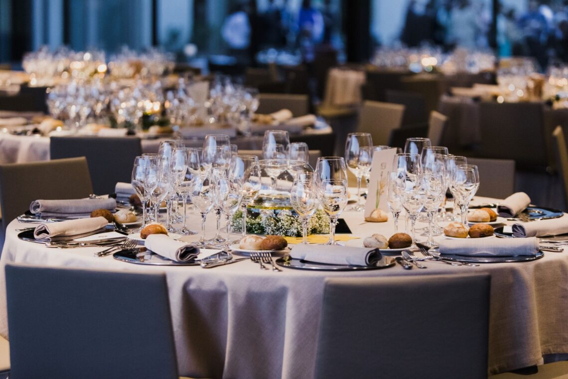 Rund eingedeckter Banketttisch mit Glasserie, Besteck und hochwertiger Tischwaesche, perfekt fuer Veranstaltungen die Tischdecken mieten nutzen